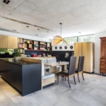 Luxury custom kitchen joinery with timber cabinetry, black kitchen island, integrated seating, and modern open-plan design.