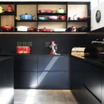 A contemporary kitchen designed around clean lines and practical functionality. Matte black cabinetry, warm timber shelving, and integrated storage create a timeless space that is both elegant and highly efficient for everyday living.